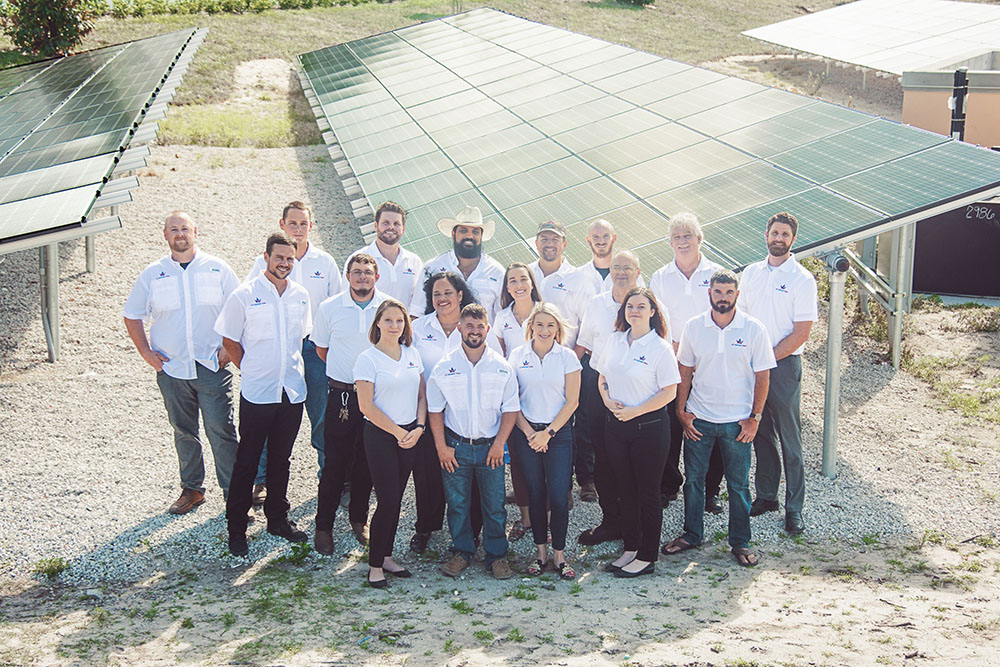 all american solar staff photo in front of agricultural solar panel system