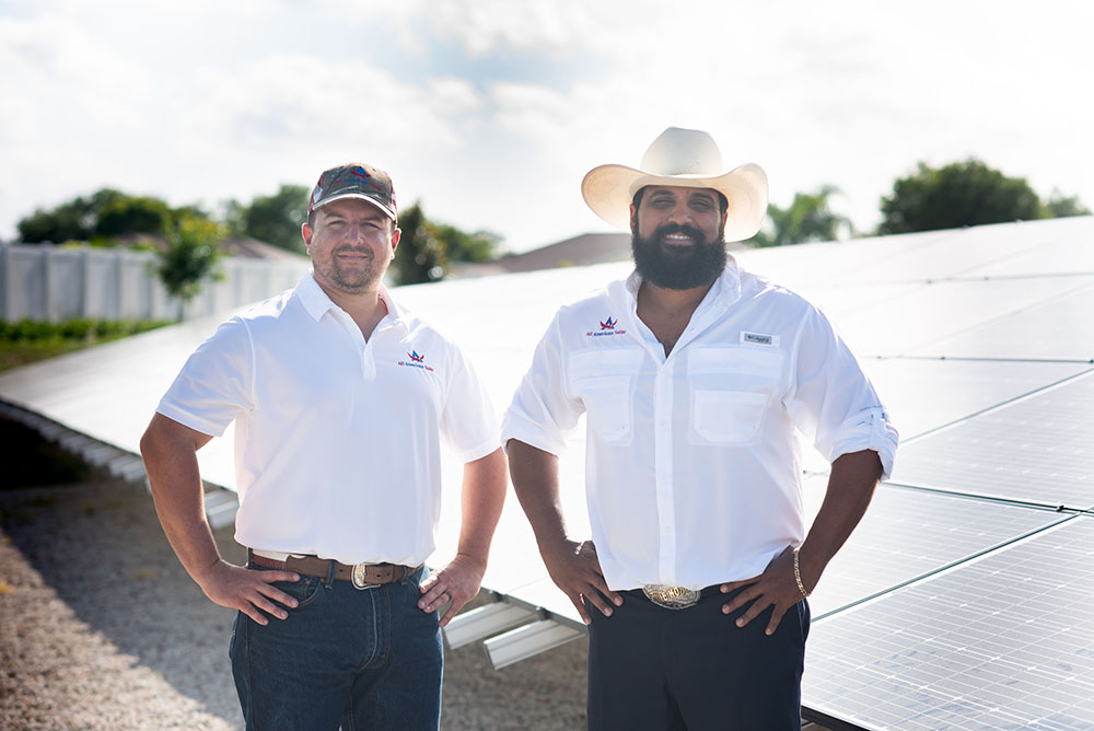 owners of all american solar standing in front of solar instillation